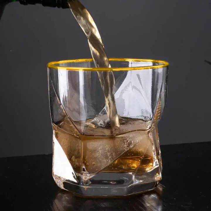 A glass of iced tea with lemon and a sprig of mint, with a honey dipper nearby.